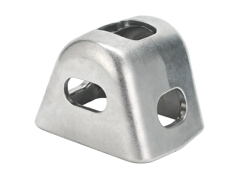 Photographed metal component with open faces and machined holes.